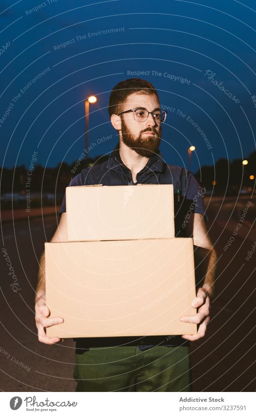 Courier delivering cardboard boxes in evening delivery courier shopping man service order pensive destination package distribution client carry customer carton