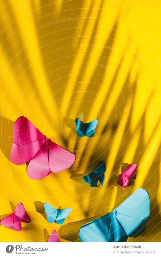 Paper butterflies on yellow cardboard butterfly decor paper carved handmade home shape composition art bright vivid vibrant origami paper craft creative hang