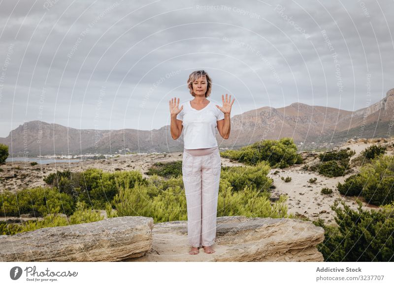 Barefoot woman meditating on stone meditation exercise rock tai chi closed eyes nature sky cloudy training female adult barefoot breath healthy fit yoga