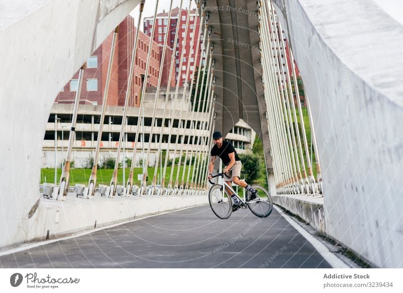Man riding a bicycle on footbridge man bike city ride modern active sportive summer male adult cap cyclist healthy adventure leisure equipment track travel town