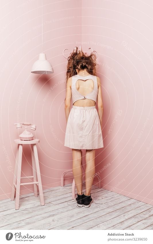 Back view of a young girl telephone wall lamp indoor pink unsatisfied long hair angry passive standing unhappy hair style loss stress haircare bad looking lady