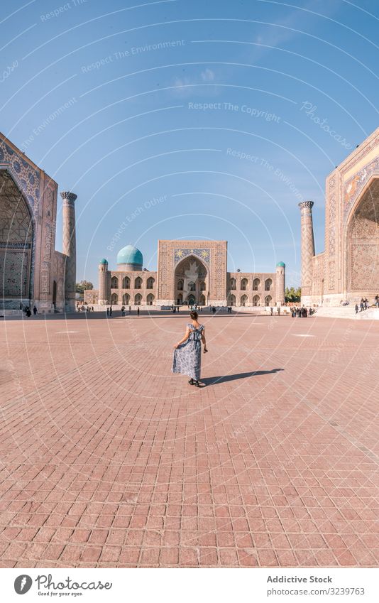 Unrecognizable female traveler walking on square tourist building traditional islamic ornament woman registan samarkand uzbekistan paved architecture oriental