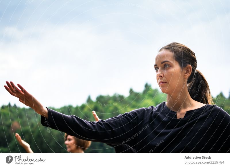 Focused woman during martial arts training focused taiji retreat nature exercise outstretched arm uniform practice female garden concentrated serious