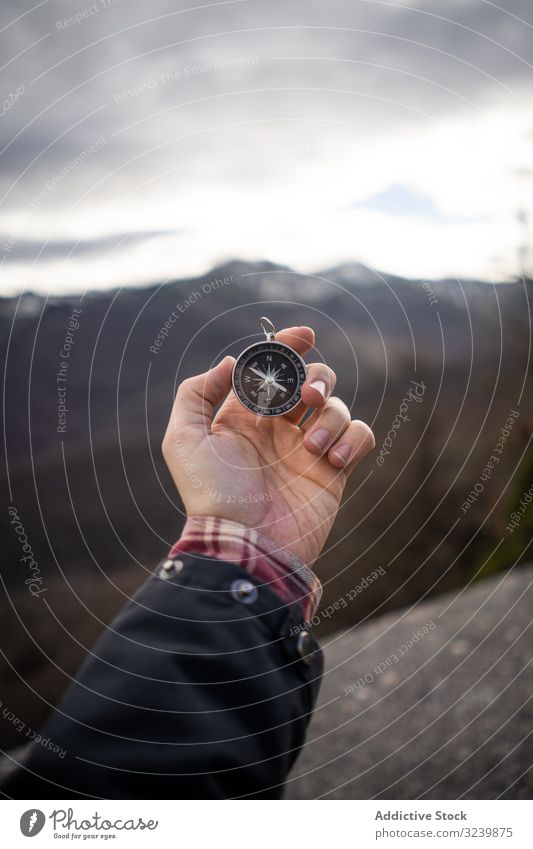 Traveler carrying compass in mountain valley traveler rocky modern hold outstretched hand stand person man adult direction trip tourism navigation geography
