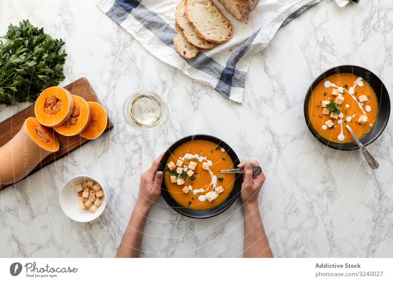 Person hands holding bowl with carrot soup cream food diet healthy vegetable pumpkin orange balanced cuisine plate fresh spoon puree delicious parsley squash