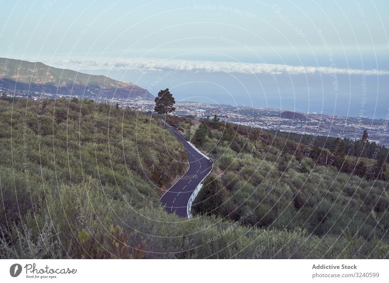 View of road going down to city under mountains town roadway park island volcano tenerife el teide spain landscape scenery asphalt scenic location cityscape