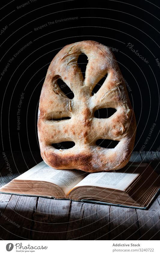 Fougasse on open recipe book bread fougasse loaf table kitchen meal food cuisine french pastry bakery tasty delicious yummy scrumptious nutrition dish prepared