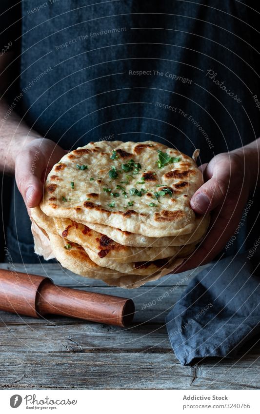 Crop man demonstrating naan bread flatbread rustic show stack fresh food cuisine cooked prepared demonstrate male culinary traditional appetizing tasty