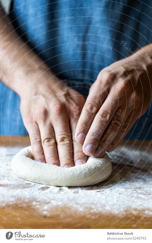 Crop man flattening dough for pizza flour soft fresh cuisine kitchen preparation food chef italian traditional male apron raw uncooked pizzeria cafe restaurant