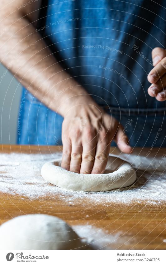 Crop man flattening dough for pizza flour soft fresh cuisine kitchen preparation food chef italian traditional male apron raw uncooked pizzeria cafe restaurant
