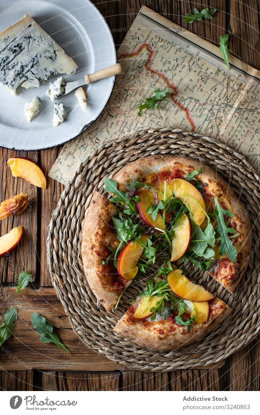Close up of summer pizza person peach arugula cheese map table piece dish sweet small cut crust tasty delicious yummy scrumptious delectable palatable savory