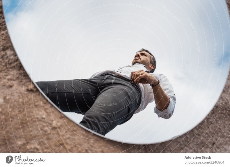 Fancy man reflecting in mirror on ground reflection fancy dreamy white shirt suspenders stand blue sky handsome oval dusty surreal usa concept pensive modern