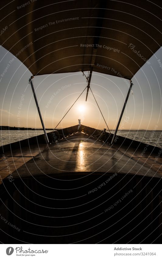Front of boat riding along sea at twilight front evening lagoon valencia ride modern vessel shade float swim smooth ocean dark sunset silhouette detail shadow