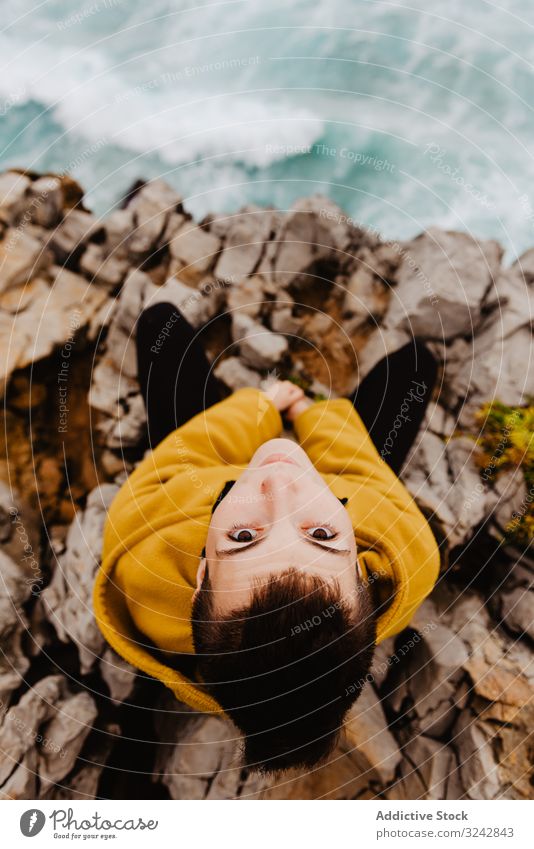 Woman in yellow hoodie on stony shore woman solitude travel wave stone watching dream harmony contemplation lonely thoughtful sea ocean horizon freedom
