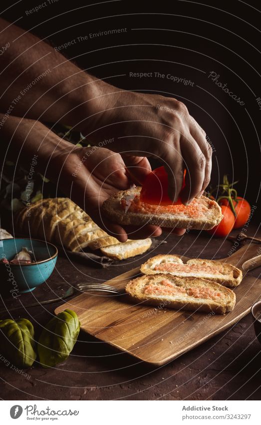 Crop person pouring tomato on toasts cook oil bread sauce food dish delicious tasty yummy fresh piece slice dinner meal bruschetta lunch vegetable basil spice