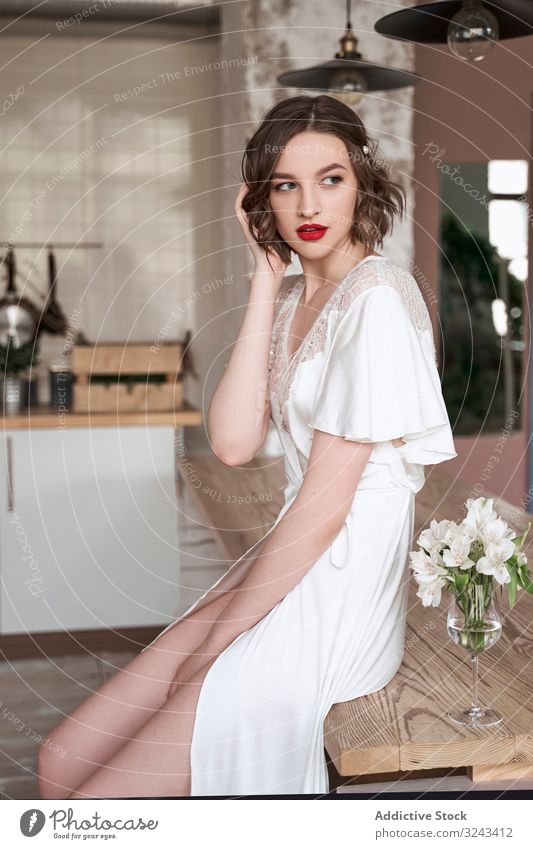 Attractive young pensive lady with red lips in white dress looking away and contemplating woman wedding dress sensual chic charm wavy hair contemplate think