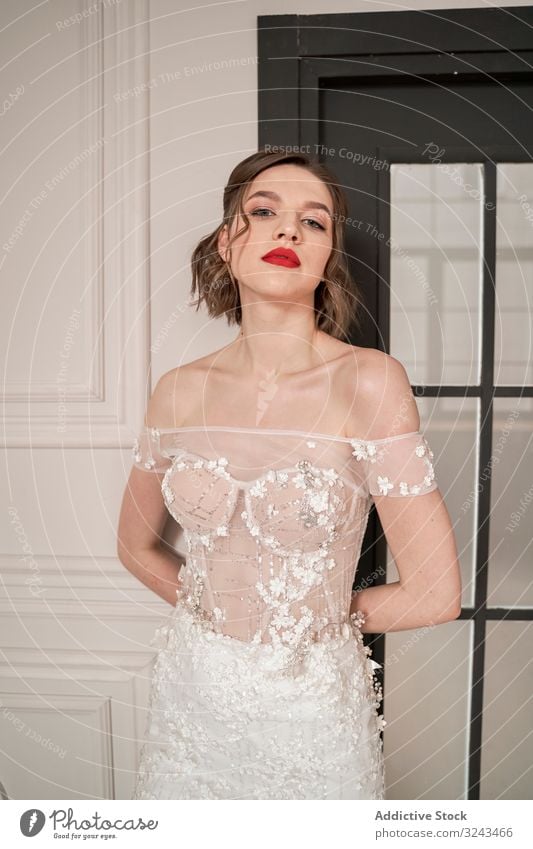 Magnificent pensive young bride in white lace dress looking at camera and pondering woman wedding dress vogue red lips elegant dream romantic chic couture