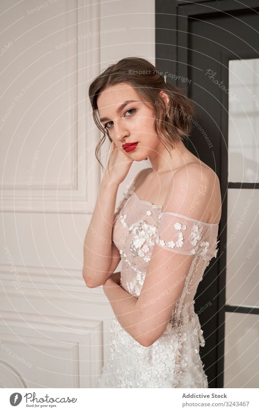 Magnificent pensive young bride in white lace dress looking at camera and pondering woman wedding dress vogue red lips elegant dream romantic chic couture