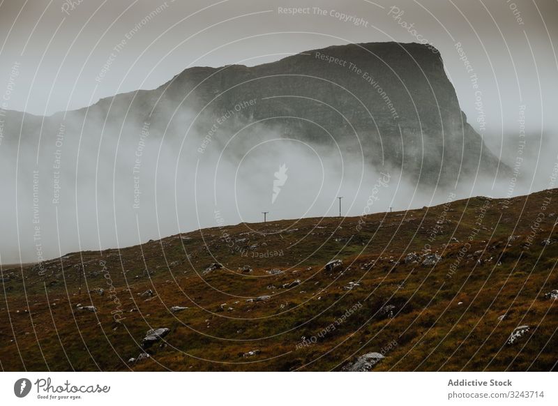 Rocky hills covered by mist in Scotland scenery landscape scenic nature dim slope valley scotland united kingdom rocky mountain wilderness thick fog haze grass