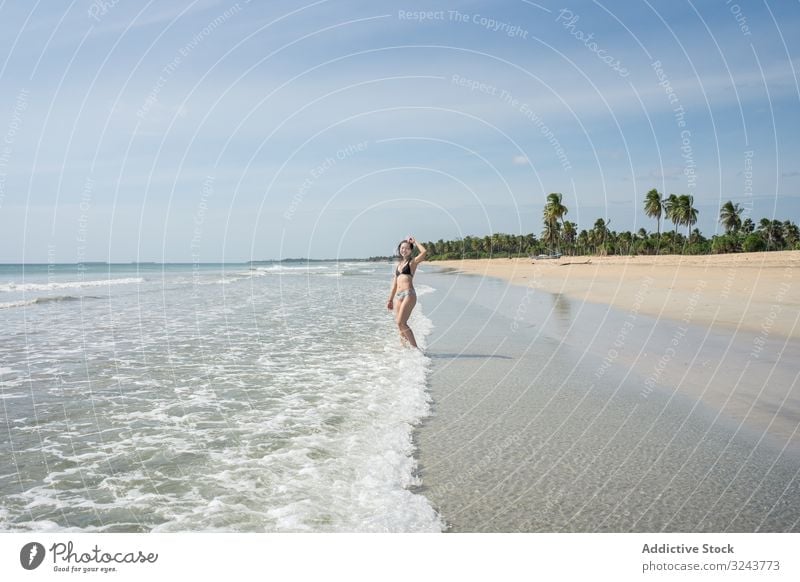 Young lady in water on sand beach with tropical forest Mirissa beach Sri Lanka island woman shore splashing cheerful young green attractive female nature fresh