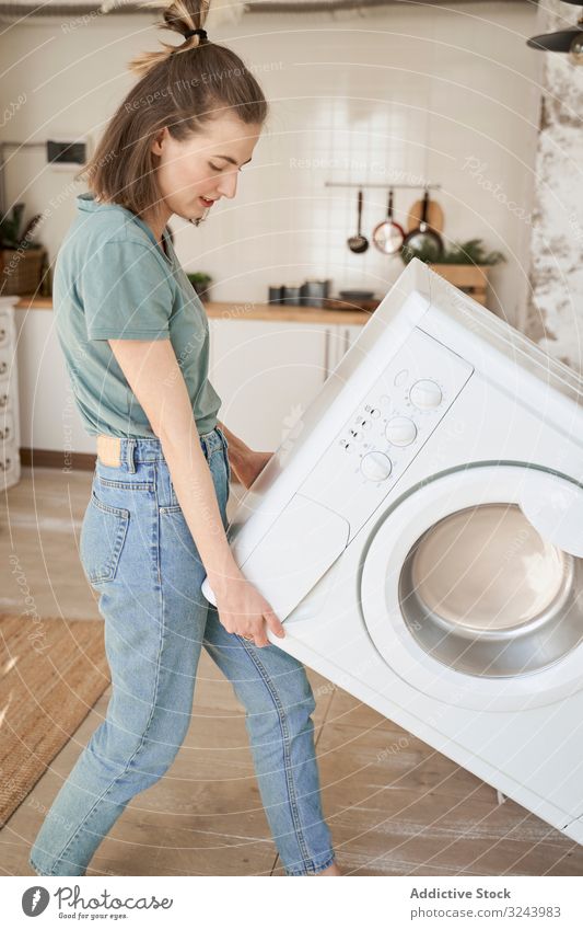 https://www.photocase.com/photos/3243983-joyful-strong-woman-carrying-washing-machine-in-kitchen-photocase-stock-photo-large.jpeg