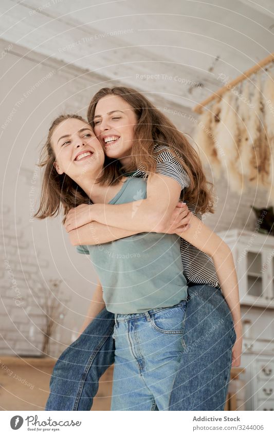 Laughing girlfriends sitting on washing machine in house home fun laugh couple domestic women leisure relocation love lounge barefoot together comfort housework