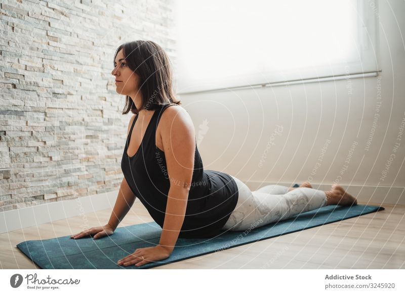 Woman meditating at home woman meditation yoga pose mat practicing morning room relaxation young brunette female wellness fit healthy calm zen peaceful activity