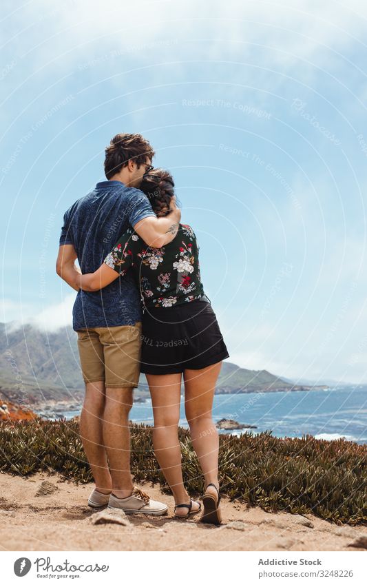 back view of amorous lovely couple embracing in big sur hill near sea intimate tender hugging landscape nature tourist relationship romantic travel together