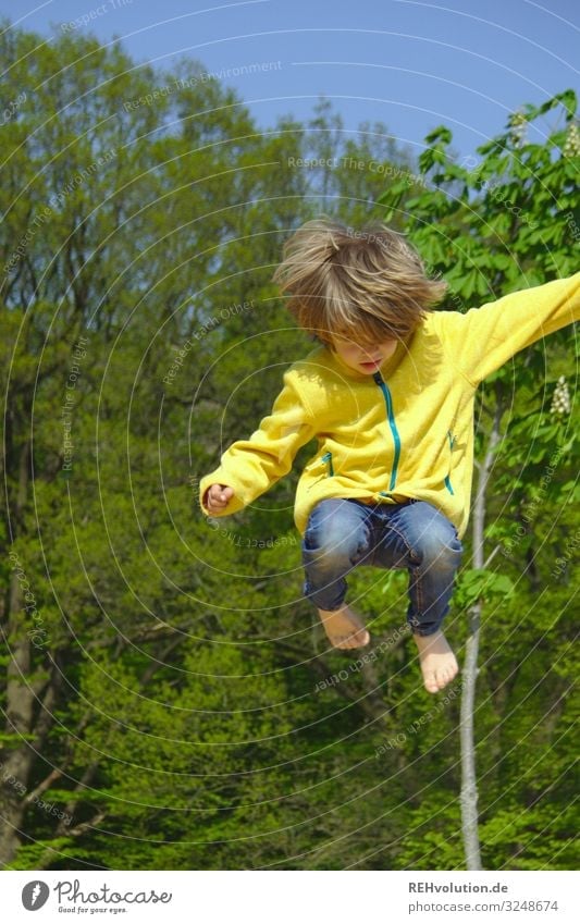 child jumps up Jump Dynamic Movement active Tall Athletic Sports Playing Playground Yellow green huts Barefoot fun Trampoline Boy (child) Jacket Summer Hop Joy