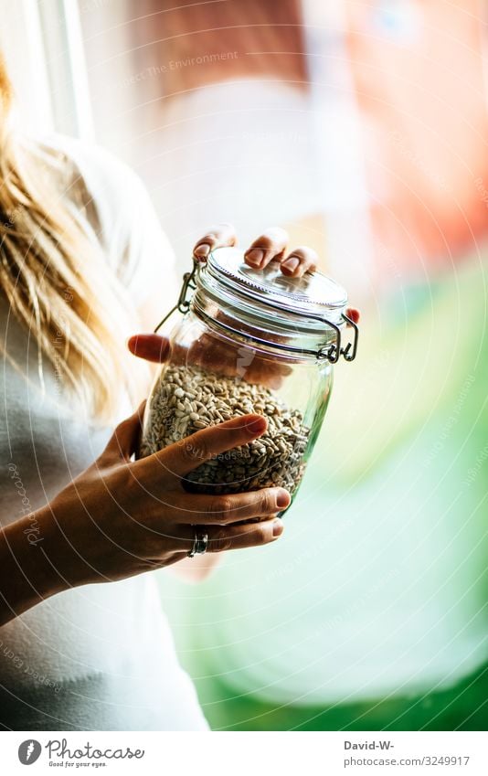 Woman with sustainable with glass container and grains in her hand Sustainability Preserving jar Glass Glass container Fear of the future Eco-friendly