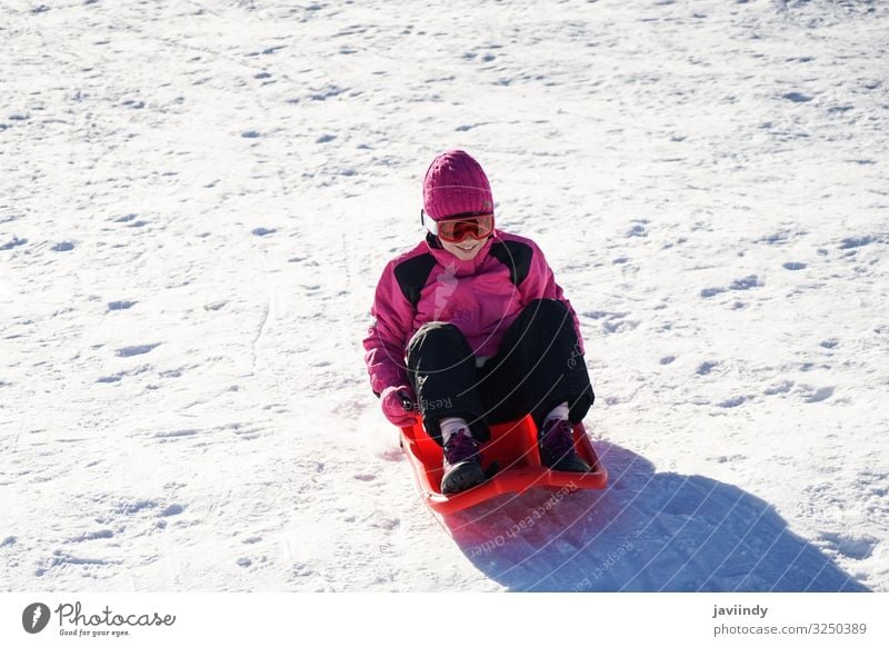 Little girl sledding at Sierra Nevada ski resort. Joy Happy Relaxation Leisure and hobbies Playing Vacation & Travel Winter Snow Mountain Sports Child