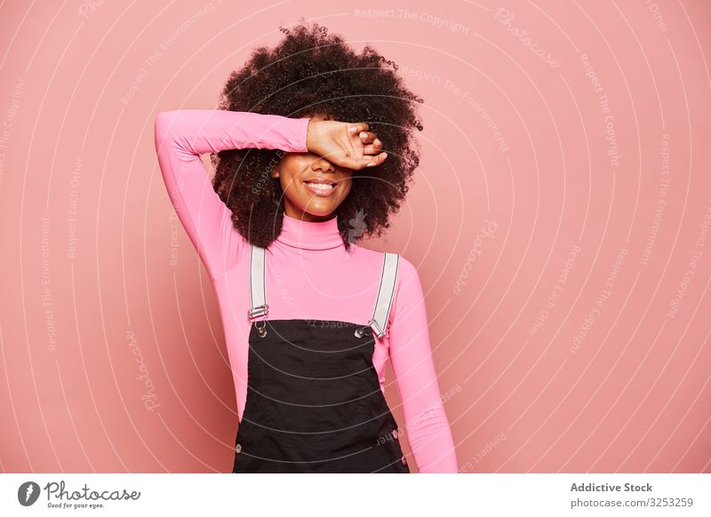 Young African American woman covering eyes with arm smile surprise waiting excited happy pink laugh cheerful female shy timid shame shyness embarrassed