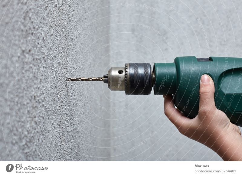 Worker drilling a hole into the wall with an electric drill. Leisure and hobbies Work and employment Tool Drill Construction machinery Human being Man Adults
