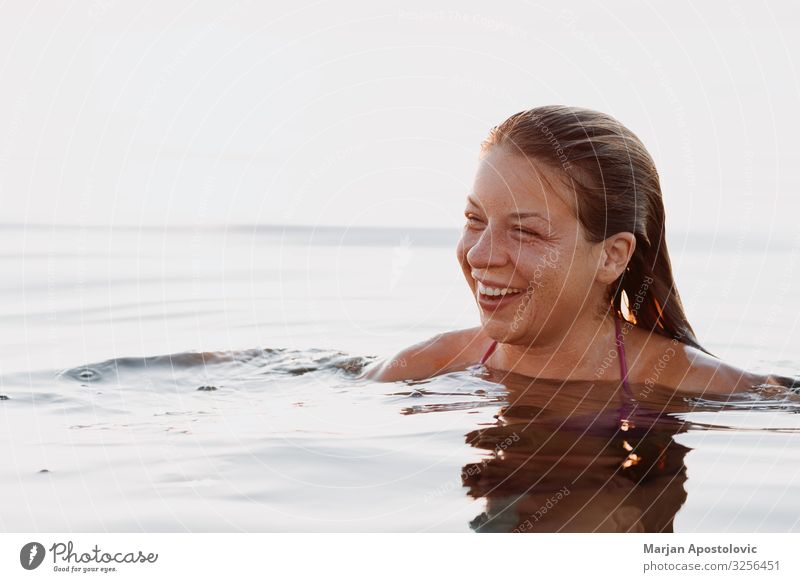 Young woman swimming and smiling Lifestyle Joy Vacation & Travel Tourism Freedom Summer Summer vacation Ocean Swimming & Bathing Human being Feminine