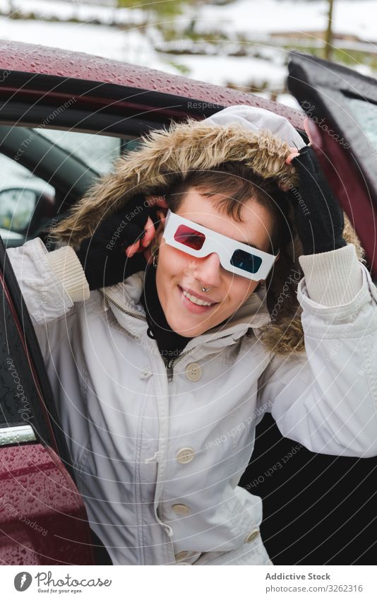 Smiling person peeping out car in winter 3d glasses peep out snow piercing hood arm warmer smile play cheerful mood charismatic content stereoscopy screen blue