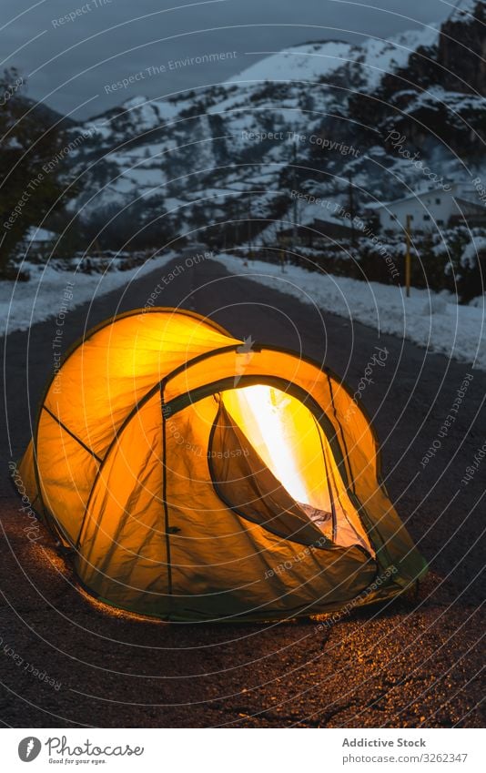 Illuminated tent in the middle of asphalt road winter mountain tourism twilight evening snow cozy adventure nature illuminate romantic relax wilderness vacation