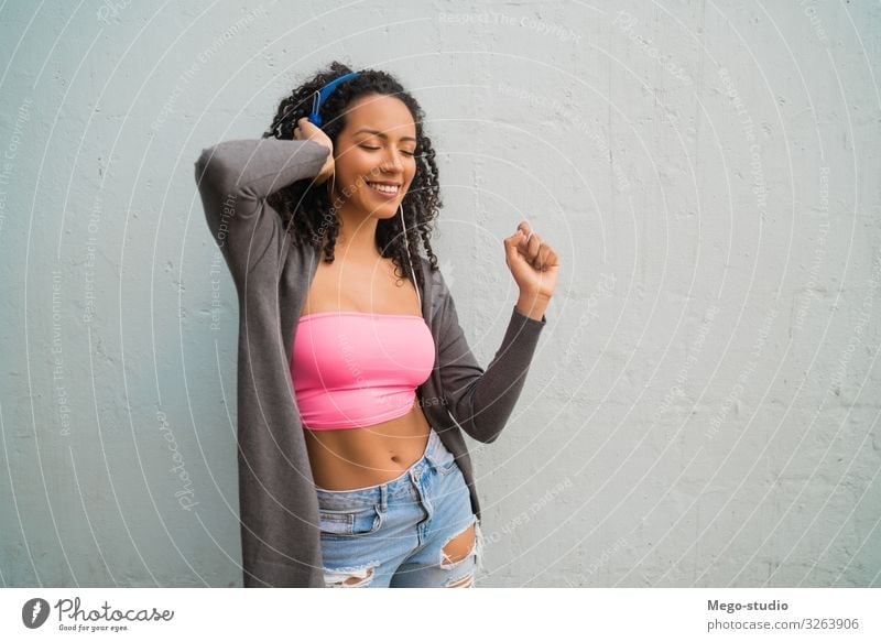 Young afro woman listening to music with headphones. Lifestyle Style Joy Happy Beautiful Music Woman Adults Afro To enjoy Listening Smiling Stand Happiness Cute