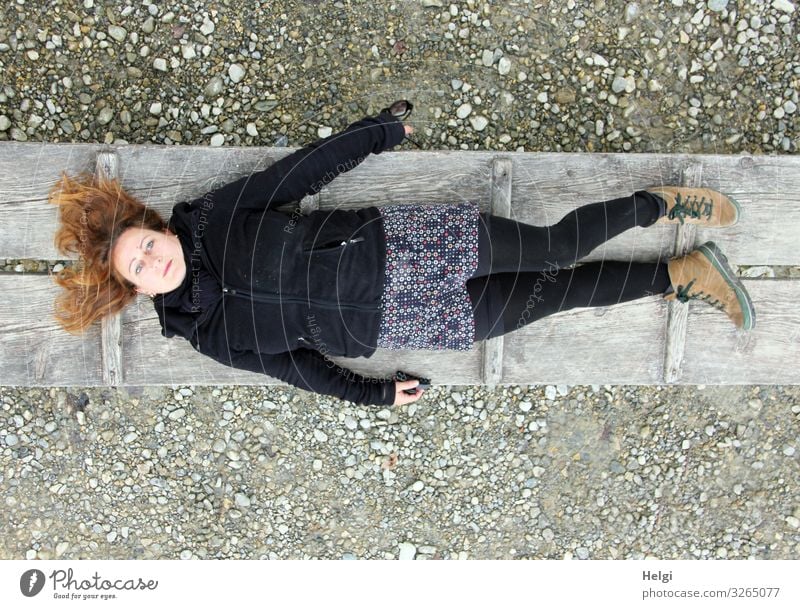 Woman with long brunette hair and dark and patterned clothes lies on a wooden jetty Human being Feminine Adults 1 45 - 60 years Earth Spring Clothing Skirt