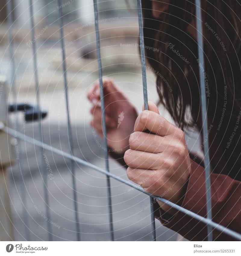 captive Human being Feminine Young woman Youth (Young adults) Woman Adults Hand Fingers Pain Loneliness Captured Fence To hold on Grating Distress Anonymous