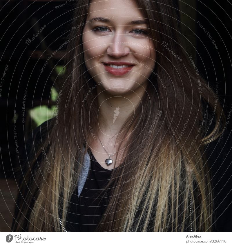 Portrait of a young woman smiling and standing in front of a dark background Style Joy already Life Well-being Barn Young woman Youth (Young adults) Face