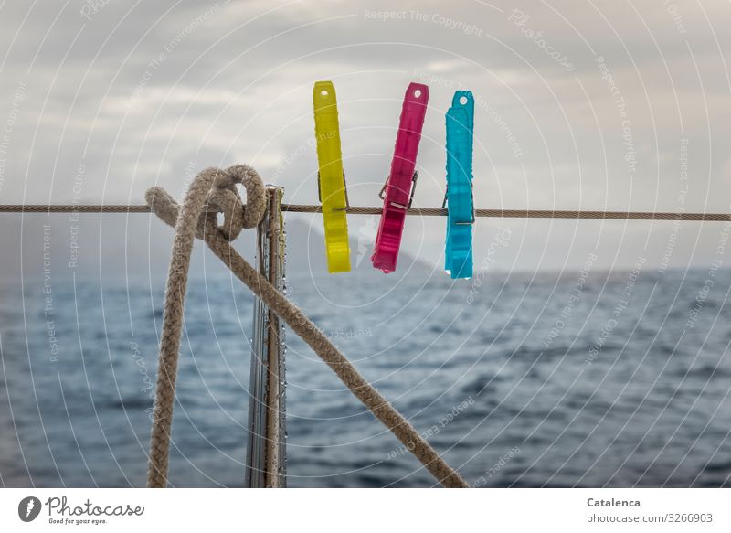Three clothes pegs on a boat railing hope for better weather Weather Bad weather Drops of water Rain Wet Water Ocean Clothes peg sailing yacht Clouds Blue Red