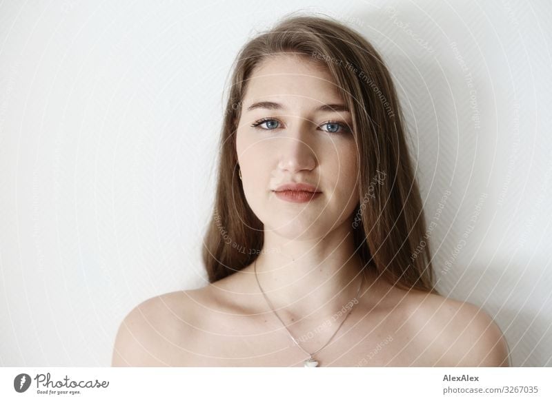 Portrait of a young woman in front of a white wall Elegant Style Joy already Wellness Life Young woman Youth (Young adults) Face 18 - 30 years Adults Jewellery