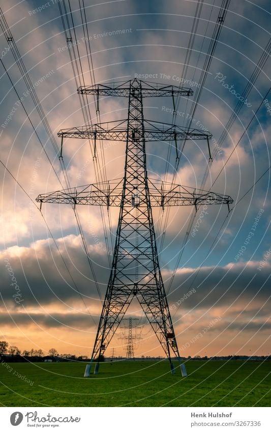 High voltage pylons in a beautiful landscape with colorful clouds in wintertime blue cable construction current danger device distribution electric electrical