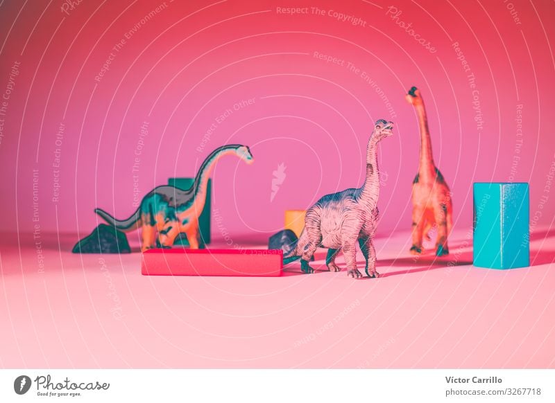 Dinos with blocks and a pink background Leisure and hobbies Climate Climate change End Apocalyptic sentiment Infancy Kitsch Multicoloured Interior shot