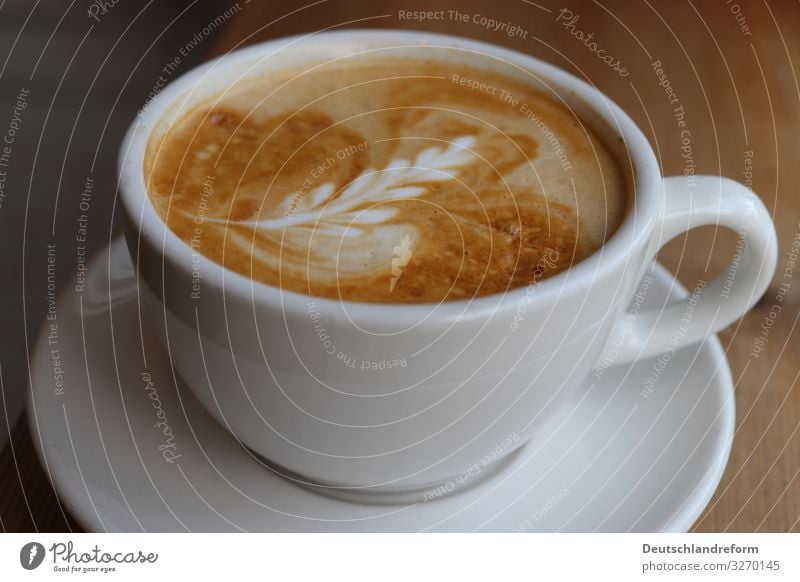 White coffee cup on white coaster on wooden table. Coffee foam with latte Art. Espresso Cup Milk Foam manner barista Breakfast Interior shot Caffeine Delicious