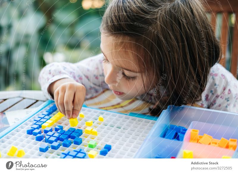 Girl playing with mosaic board game girl creative focused concentration piece colorful concentrate education puzzle assemble fun child childhood kid little