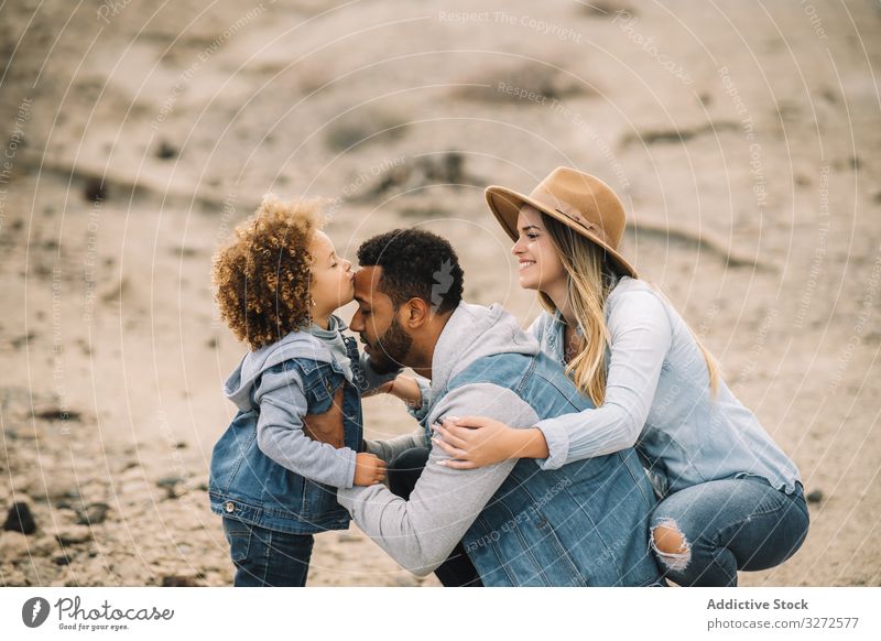 Happy multiethnic family gathering on nature fun parent toddler play rest sand smile happy cheerful lifestyle modern child man bonding love tender casual kid