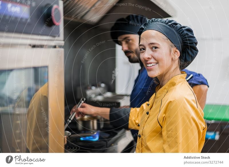 Professional chef and assistant working in kitchen colleagues frying pan dish professional cook stove together coworker staff control cooperation flame gas