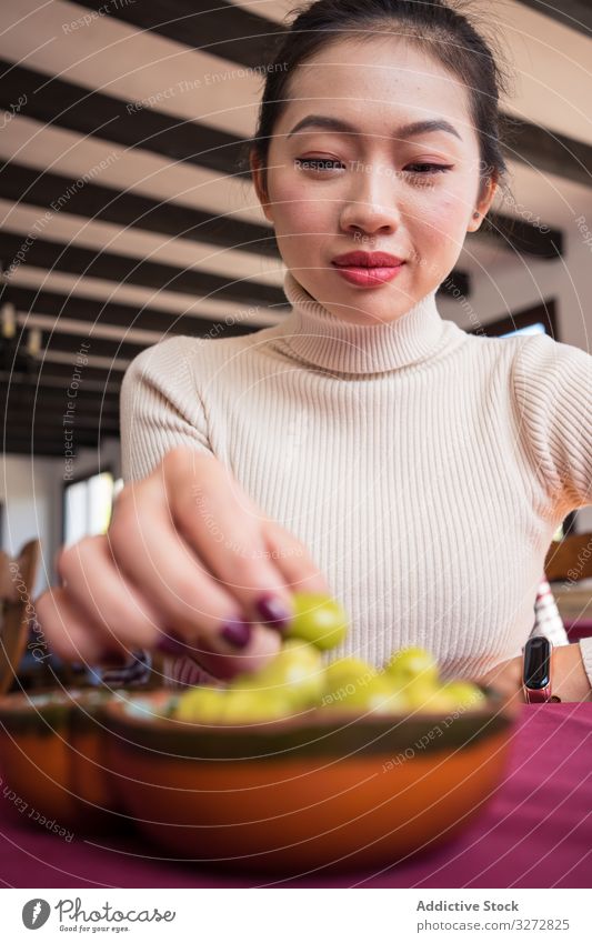 Asian woman eating olives in restaurant cafe food meal lifestyle carratraca malaga spain snack appetizer delicious female asian breakfast healthy culture