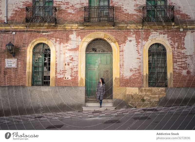 Woman on street with aged building woman spain travel antique malaga carratraca historical facade lifestyle freedom holiday journey adventure vintage exterior